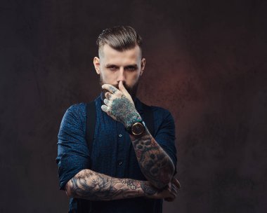Mavi bir gömlek ve pantolon askısı, şiddetli eski moda hipster adam bir stüdyoda poz.