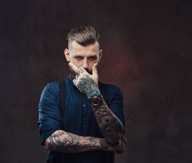 Mavi bir gömlek ve pantolon askısı, şık moda hipster adam gösterir orta parmak kamera.