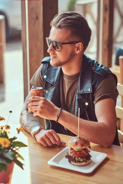 Bokovky s stylový účes a plnovous sedí u stolu, zastavil na oběd na silnici kavárna. — Stock fotografie