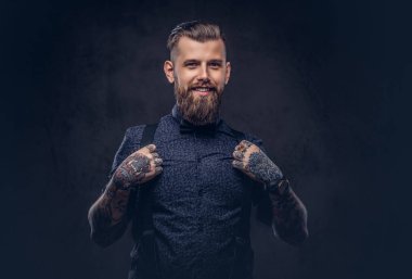 Mavi bir gömlek ve pantolon askısı, gülümseyen yakışıklı eski kafalı Yeniyetme bir stüdyoda poz.