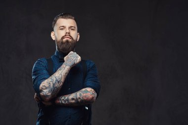 Mavi bir gömlek ve pantolon askısı, çene bir stüdyoda el ile ayakta dalgın yakışıklı eski moda hippi.