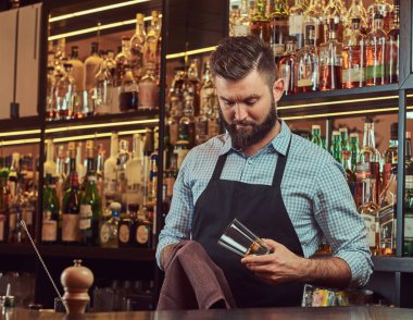 Şık acımasız barmen bir bezle bar counter arka plan cam temizlik.