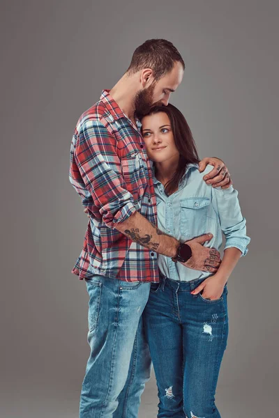 Atractiva pareja, hombre barbudo y chica morena abrazándose en un estudio . — Foto de Stock