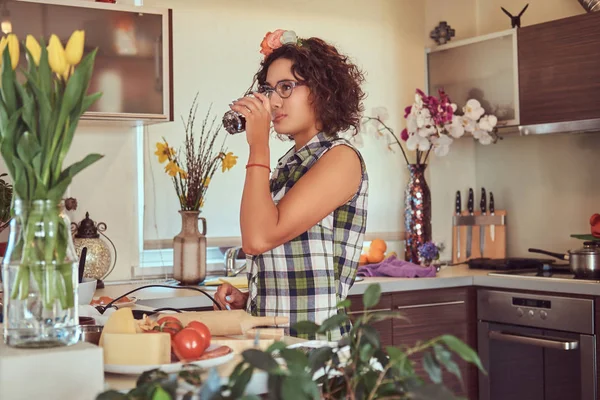 Charmig lockigt spansktalande tjej matlagning i hennes kök. — Stockfoto