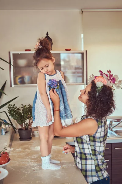 Hermosa madre hispana calma a su hija dulce disgustado en una cocina . —  Fotos de Stock