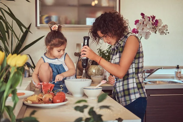 Hermosa madre hispana enseña a su linda hijita a preparar pizza en la cocina . —  Fotos de Stock