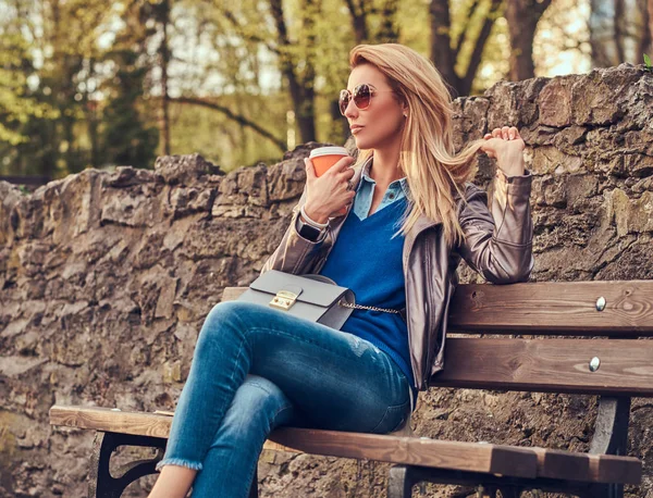 Fashionabla Blond Kvinna Slappnar Utomhus Dricka Takeaway Kaffe Sittande Bänken — Stockfoto