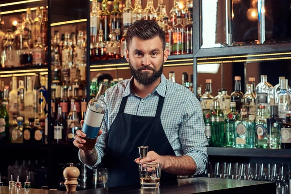 Bir gömlek ve önlük şık acımasız barmen, bir kokteyl bar counter arka plan yapar. — Stok fotoğraf