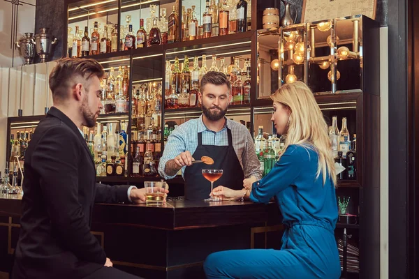 Elegante brutal barman serve um atraente casal que passar uma noite em um encontro . — Fotografia de Stock