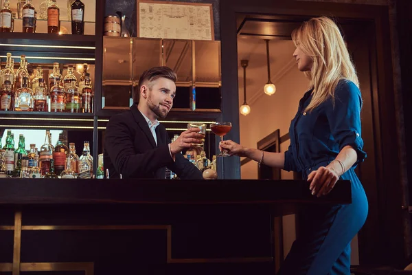 Casal elegante está passando a noite em um ambiente romântico, bebendo vinho no balcão do bar . — Fotografia de Stock