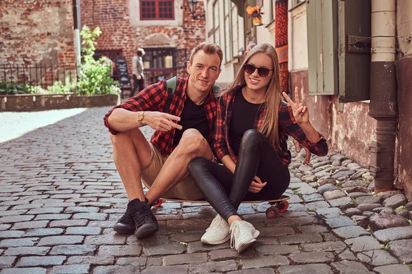 Junges glückliches Hipster-Paar, ruht sich beim Spaziergang auf dem Bürgersteig in der alten Europastraße aus. — Stockfoto