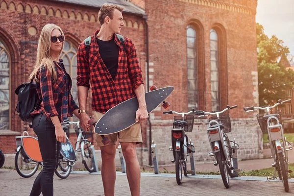Hipster молода пара, красивий фігурист і його подруга ходить по старих вулицях Європи. — стокове фото