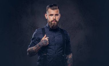 Yakışıklı bir eski moda hippi bir stüdyoda poz mavi bir gömlek ve pantolon askısı, portresi.