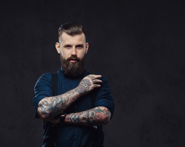 Mavi bir gömlek ve bir stüdyo çapraz kollarında ile ayakta pantolon askısı, yakışıklı eski moda hippi.