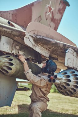 Düzgün ve uçan kask mekanik onarım eski savaş savaşçı Interceptor bir açık hava Müzesi'nde.