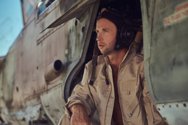 Üniforma ve uçan yakınındaki, Açık Hava Müzesi'nde eski bir bombardıman uçak altında duran bir mekanik yakın çekim portre.