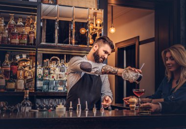 Şık acımasız barmen çekici bir kadın hizmet vermektedir. 