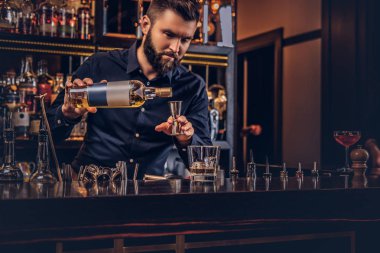 Şık acımasız barmen siyah gömlekli bir kokteyl bar counter arka plan yapar.