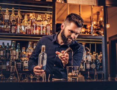 Şık acımasız barmen siyah gömlekli bir kokteyl bar counter arka plan yapar.