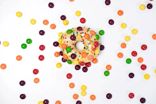 Appetizing golden donut sprinkled with colorful chocolate pellets. — Stock Photo, Image