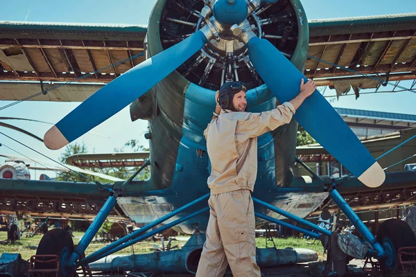 飞行员或机械工在一个完整的飞行齿轮检查他的复古军用飞机的螺旋桨飞行前. — 图库照片