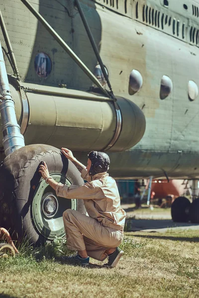 Mecânico em uniforme e capacete voador lavar grande helicóptero militar . — Fotografia de Stock