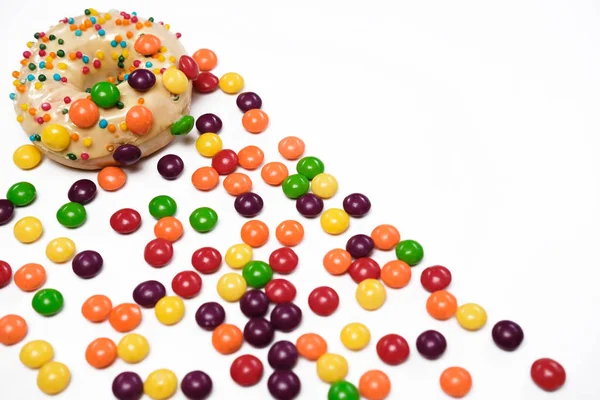 Appetizing golden donut sprinkled with colorful chocolate pellets. — Stock Photo, Image