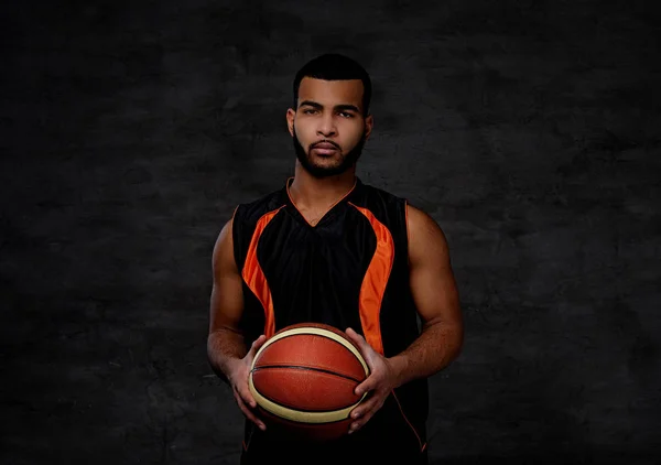 Jovem jogador de basquete afro-americano em sportswear isolado sobre fundo escuro . — Fotografia de Stock