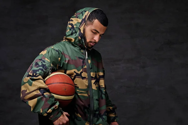 Portret van een jonge Afro-Amerikaanse straat basketbalspeler in een camouflage jasje. — Stockfoto