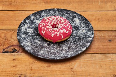 İştah açıcı çörek ile yalan bir ahşap tahta arka plan üzerinde sprinkles..