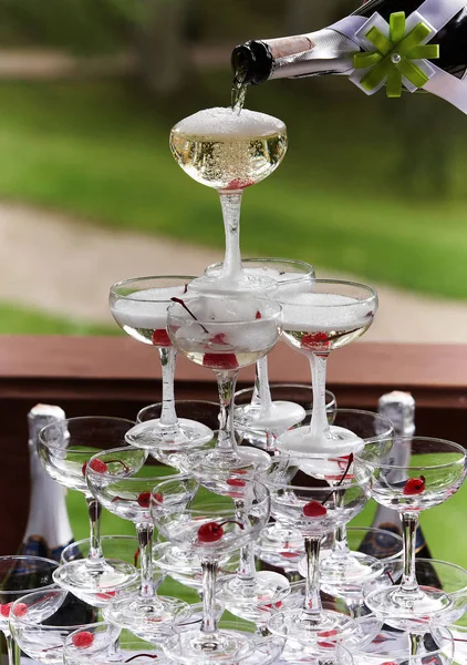 Champagne glasses standing in a tower at a festive event, party or wedding reception.