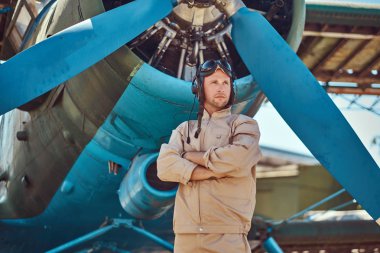 Askeri uçak yakın Çapraz kollar ile ayakta tam uçuş viteste yakışıklı pilot.