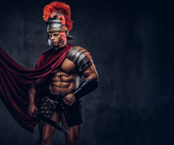 Portrait of a brutal Roman legionary in battle uniforms on a dark background.