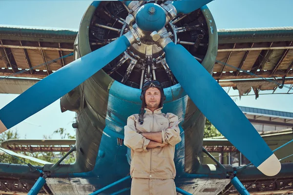 Askeri uçak yakın Çapraz kollar ile ayakta tam uçuş viteste yakışıklı pilot.