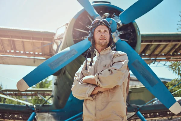 Askeri uçak yakın Çapraz kollar ile ayakta tam uçuş viteste yakışıklı pilot.