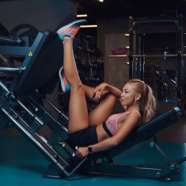 美丽健身妇女在运动的运动的腿压机在健身房 — 图库照片