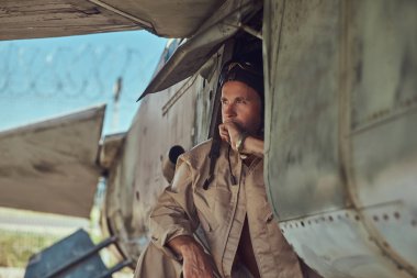 Üniforma ve uçan yakınındaki, Açık Hava Müzesi'nde eski bir bombardıman uçak altında duran bir mekanik yakın çekim portre.