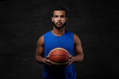 Afro-Amerikan bir sporcu portresi. Karanlık bir arka plan üzerine bir top ile spor basketbol oyuncusu.