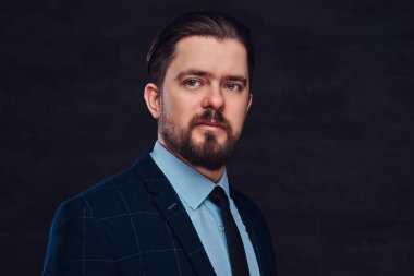 Yakın çekim portre sakal ve saç modeli ile yakışıklı bir orta yaşlı adamın dokulu bir koyu arka plan Studio bir zarif resmi kıyafeti giymiş.