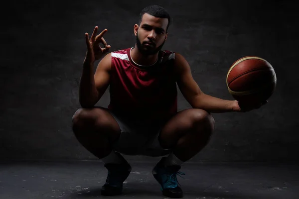 Jugador Baloncesto Afroamericano Ropa Deportiva Cuclillas Con Una Pelota Aislado — Foto de Stock
