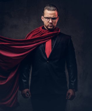 Karanlık bir arka plan üzerinde kırmızı kravat siyah elbiseli dahi süper kahraman portresi. 