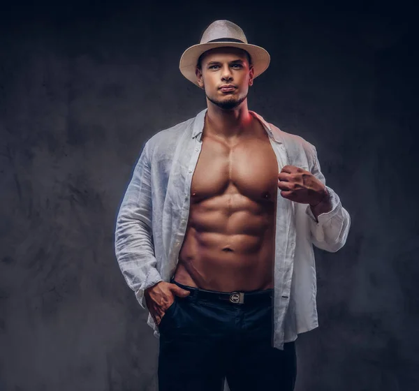 Retrato de um cara bonito sexy com corpo muscular em uma camisa branca desabotoada e chapéu de panamá . — Fotografia de Stock