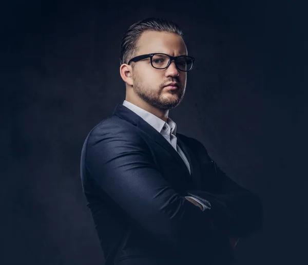 Bel homme d'affaires élégant avec un visage sérieux dans un élégant costume formel debout avec les bras croisés. Isolé sur un fond sombre . — Photo