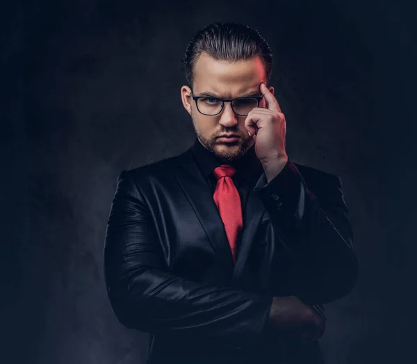 Retrato de un hombre con estilo pensativo en un traje negro y corbata roja . —  Fotos de Stock