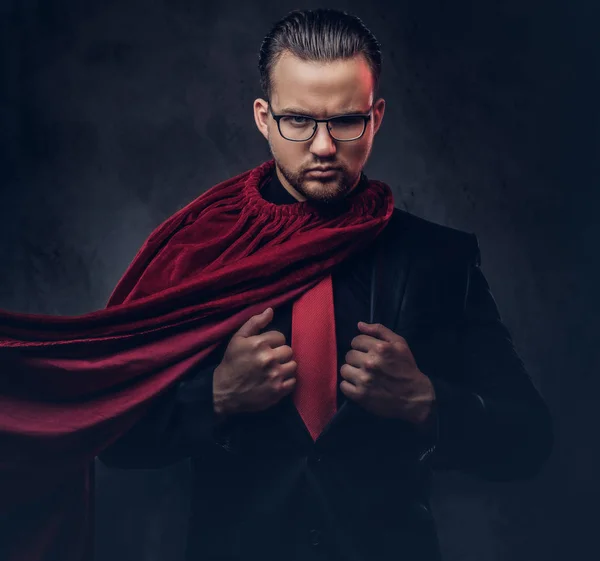 Portrait d'un super héros de génie en costume noir avec une cravate rouge sur un fond sombre . — Photo