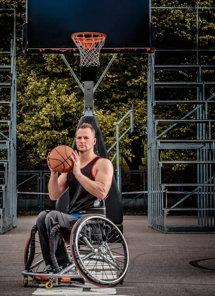 Retrato de um jogador de basquete com deficiência em uma cadeira de rodas em um campo de jogos aberto . — Fotografia de Stock