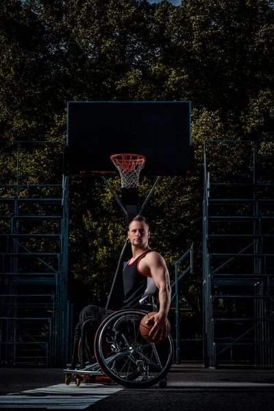 Retrato de um jogador de basquete com deficiência em uma cadeira de rodas em um campo de jogos aberto . — Fotografia de Stock