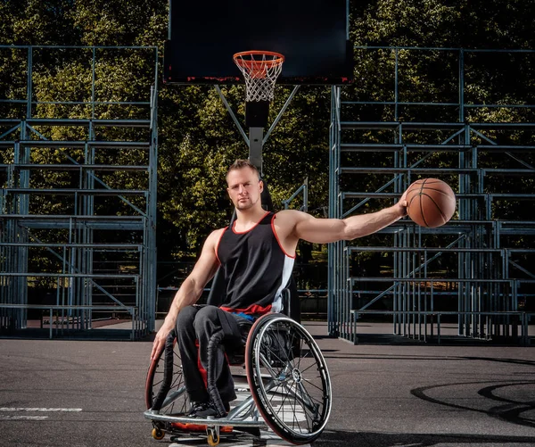 Retrato de um jogador de basquete com deficiência em uma cadeira de rodas em um campo de jogos aberto . — Fotografia de Stock