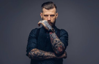 Dalgın yakışıklı eski moda hipster gömlek ve pantolon askısı, çene üzerinde el ile poz.