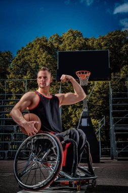 Bir tekerlekli sandalye poz açık oyun zeminde topuyla güçlü basketbolcu.